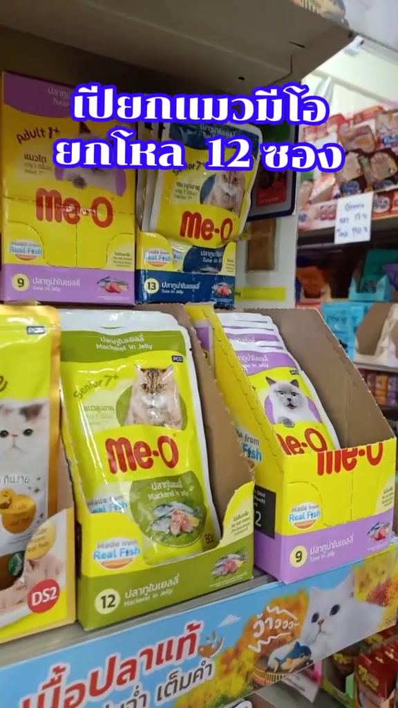 กล่องอาหารเปียกแมว Me-O แบบซองหลายรสวางเรียงซ้อนกันบนชั้นวาง