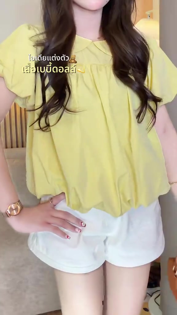 เสื้อเบบี้ดอลล์สีเหลืองจับคู่กับกางเกงขาสั้นสีขาว ถ่ายช่วงลำตัวไม่เห็นหน้า
