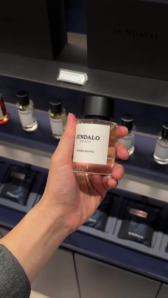 มือถือขวดน้ำหอม SÚNDALO Exclusive กลิ่น Hidden Santal ฉลากขาวหน้าชั้นวางขวดในร้าน