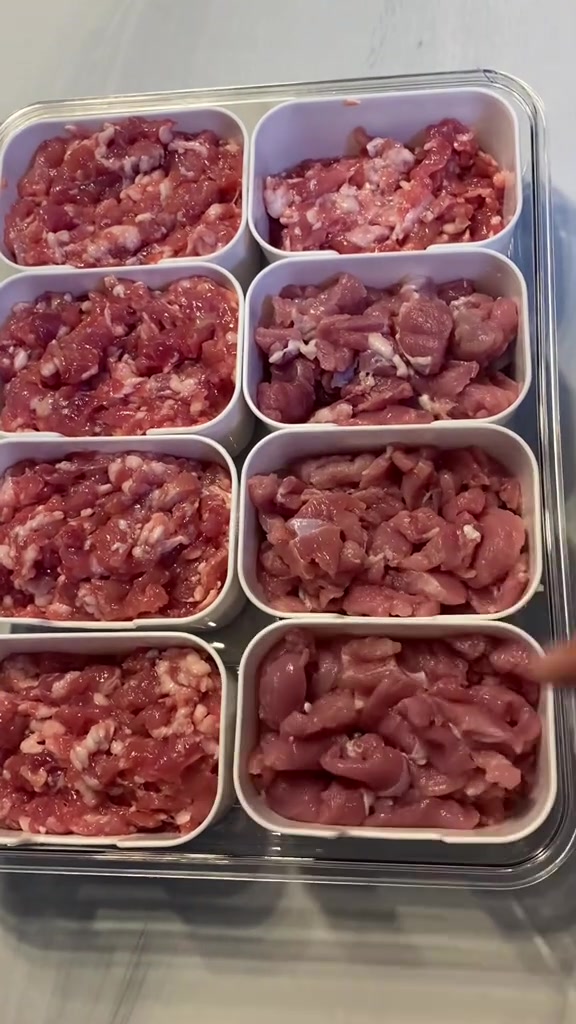 ถาดแบ่งแปดช่องใส่หมูหั่นชิ้นและหมูสับเต็มทุกช่อง วางเรียงบนฝาใส เตรียมเข้าช่องฟรีซ