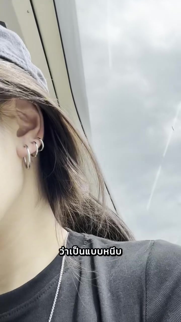 ใบหูด้านข้างสวมห่วงหนีบสีเงินสามวงเรียงกัน