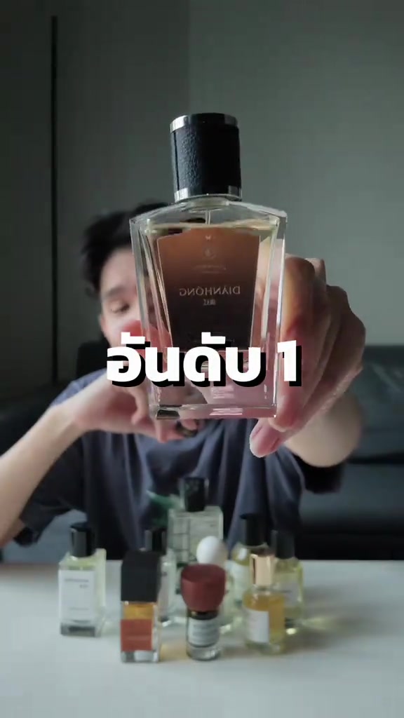 ขวดน้ำหอมฉลากขาวอ่านว่า DIĀNHÓNG ถูกชูชิดกล้อง เห็นน้ำหอมสีอ่อนภายในขวด