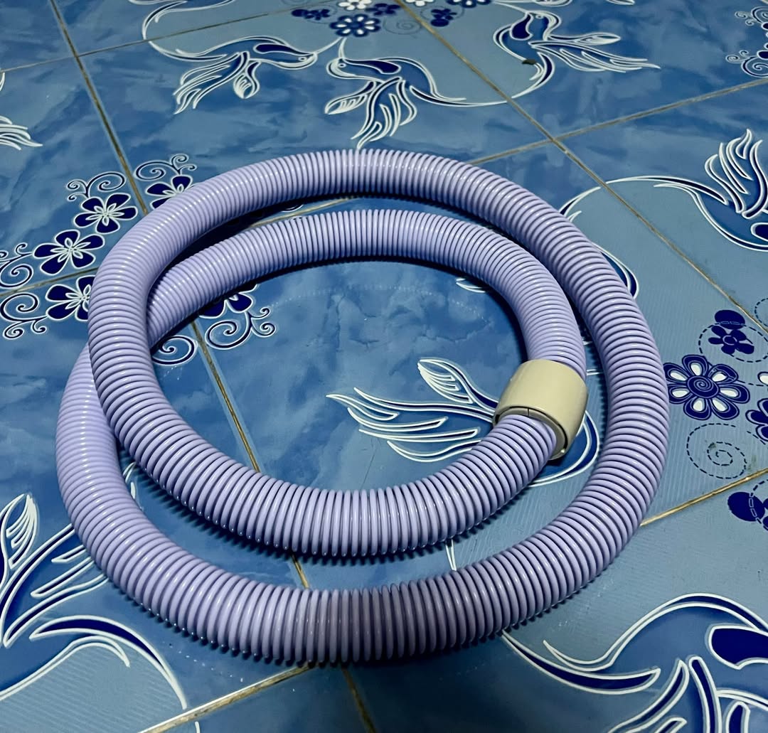 ฮูลาฮูปสปริงสีม่วงอ่อนม้วนเป็นวงวางบนพื้นกระเบื้องลายดอกไม้สีน้ำเงิน