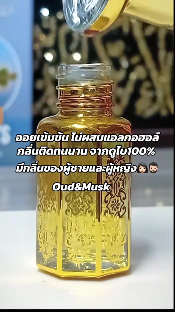 ขวดออยล์แก้วลายทองแบบอาหรับตั้งบนโต๊ะขาว มีหลอดหยดค้างอยู่เหนือปากขวด