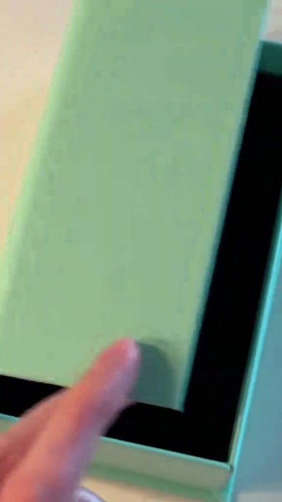 มือกำลังเปิดฝากล่องน้ำหอมสีเขียวมินต์ของแอนติโดทส์