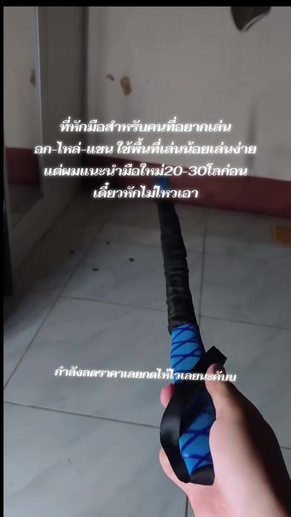 มุมมองบุคคลที่หนึ่ง มือถือสปริงมือหักด้ามโฟมสีน้ำเงินชี้ลงพื้นกระเบื้องในบ้าน พร้อมเริ่มออกกำลังกาย