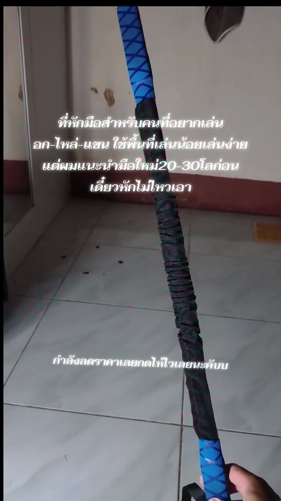 มุมมองจากมือคนถือสปริงมือหักตั้งชัน เห็นขดสปริงกลางแท่งและด้ามจับโฟมสีน้ำเงินทั้งสองข้างชัดเจน