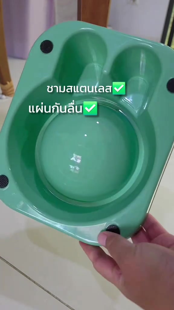 ด้านล่างของชามกันมดสีเขียวเห็นรางน้ำล้อมฐานและแผ่นกันลื่นสี่มุม