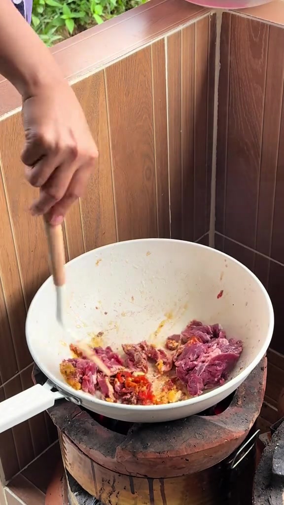 ผัดเนื้อกับพริกแกงในกระทะเคลือบหินอ่อนทรงลึกบนเตา