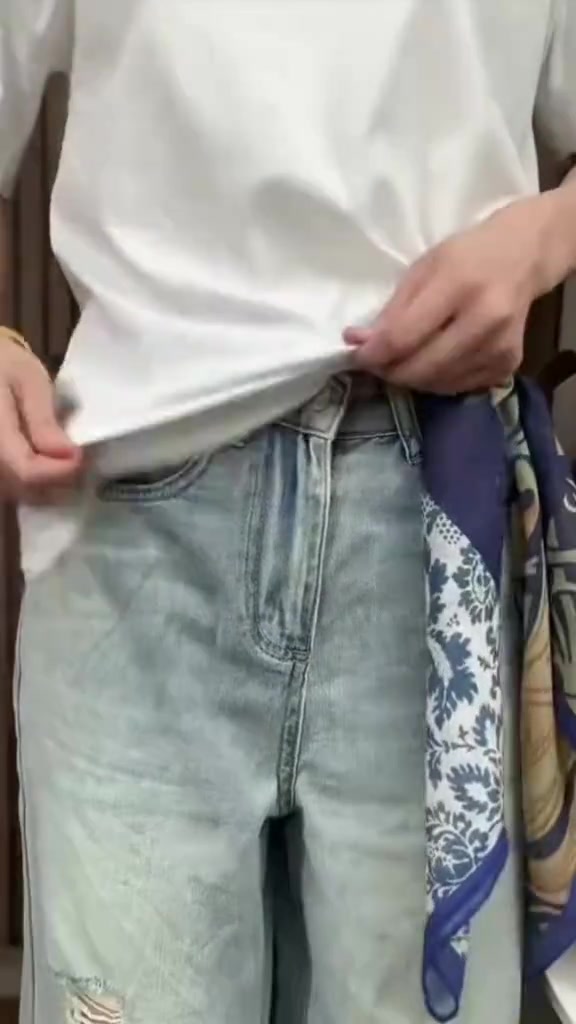 ลุคจบเสื้อยืดขาวกับยีนส์ฟอกจางมีผ้าลายน้ำเงินทองทิ้งชายที่ข้างเอว