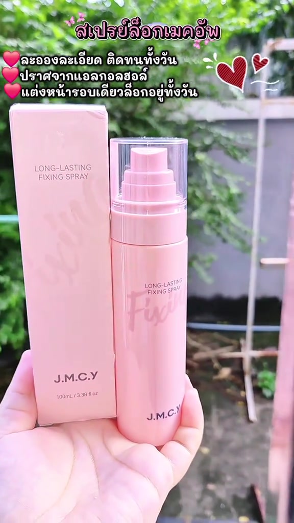 ขวดสเปรย์เจเอ็มซีวายสีชมพูวางคู่กล่องบรรจุภัณฑ์บนฝ่ามือ เห็นชื่อยี่ห้อและปริมาณ 100 มล. ชัด