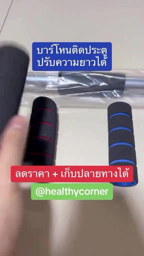ปลอกโฟมจับบาร์สีดำสองปลอก ปลอกหนึ่งแถบแดงอีกปลอกแถบน้ำเงิน วางคู่กับบาร์โหนที่ยังห่อพลาสติกอยู่บนโต๊ะ