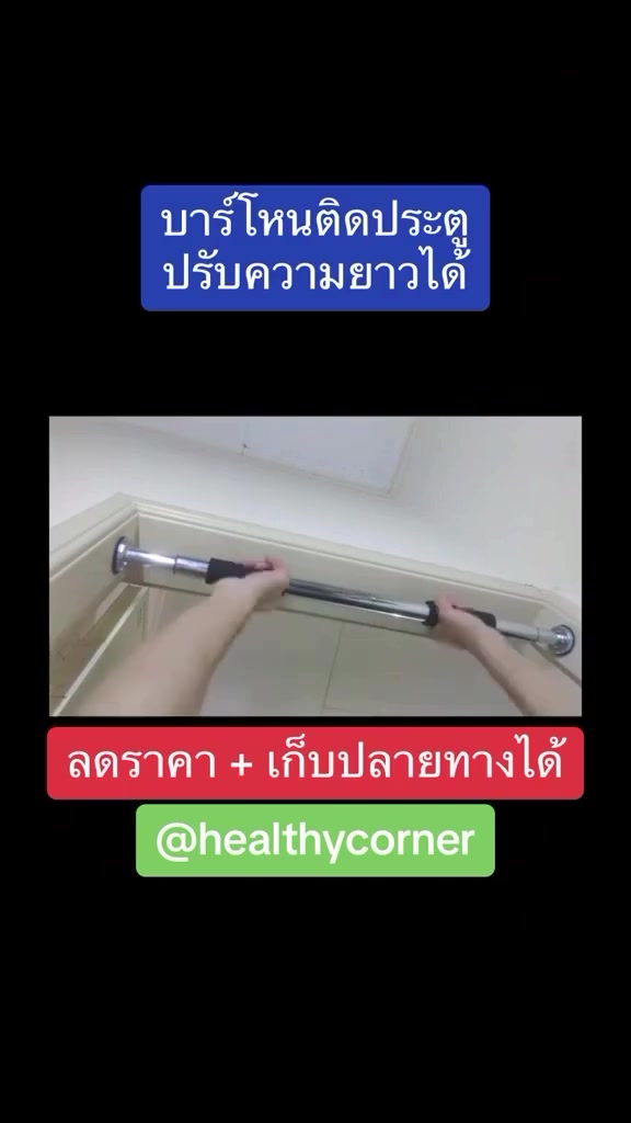 มือสองข้างยกบาร์โหนโครเมียมปรับความยาวขึ้นไปเทียบวงกบประตูสีขาวด้านบนก่อนหมุนล็อก