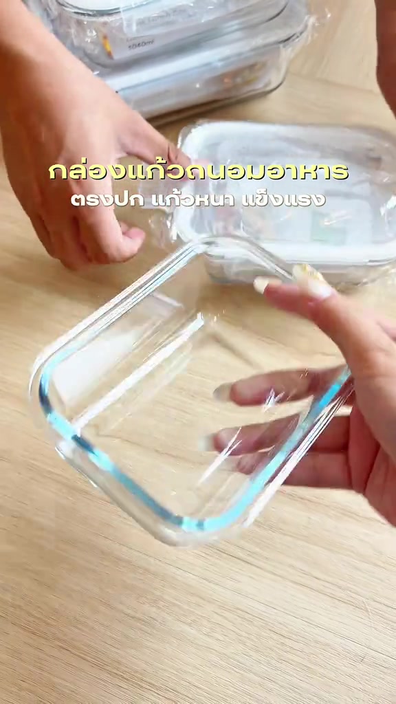 มือถือกล่องแก้วถนอมอาหารใสเปล่าขอบหนาเหนือโต๊ะไม้