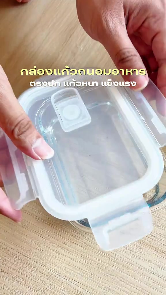 นิ้วมือกำลังง้างคลิปที่ฝากล่องแก้ว เห็นปุ่มระบายอากาศซิลิโคนกลางฝา
