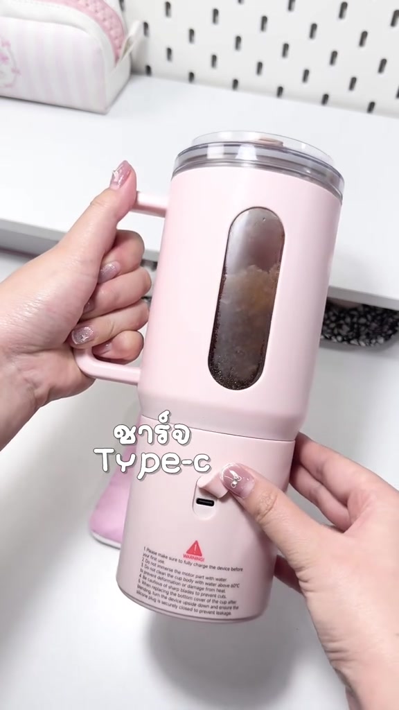 ด้านข้างฐานเครื่องปั่นสีชมพู เห็นช่องชาร์จ Type-C กับสติกเกอร์คำเตือนการใช้งานใต้ช่องชาร์จ