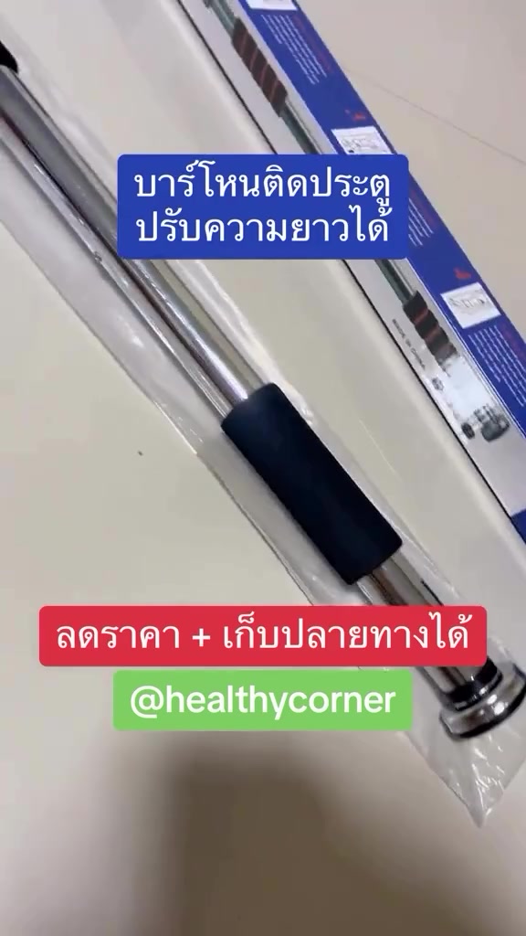 บาร์โหนปรับความยาวยังอยู่ในถุงพลาสติกใสวางพาดกล่องสินค้าสีน้ำเงินขาวบนโต๊ะสีครีม