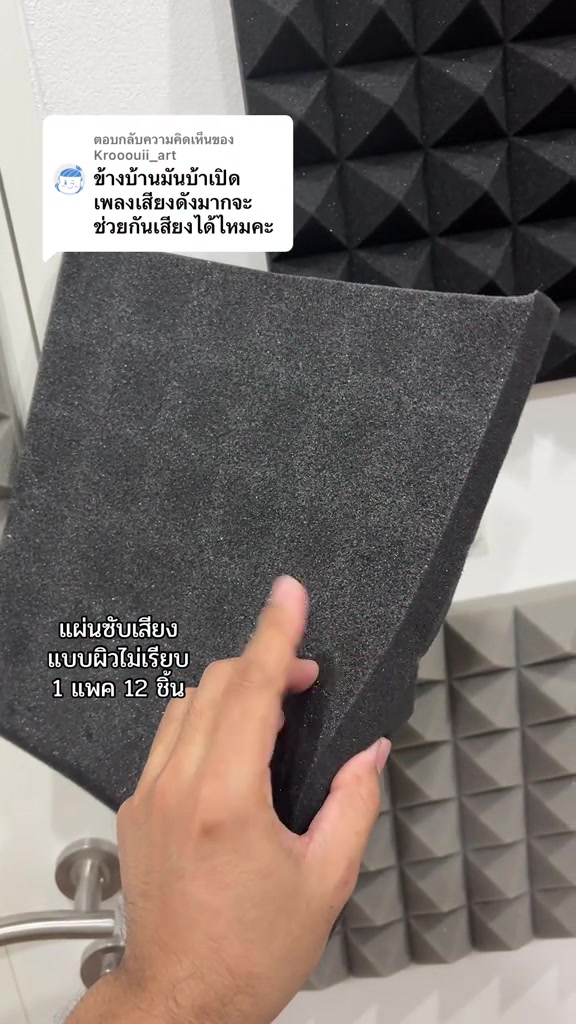 มือถือแผ่นโฟมซับเสียงสีเทาเข้มให้เห็นความหนาและผิวหลังแผ่นที่เรียบ