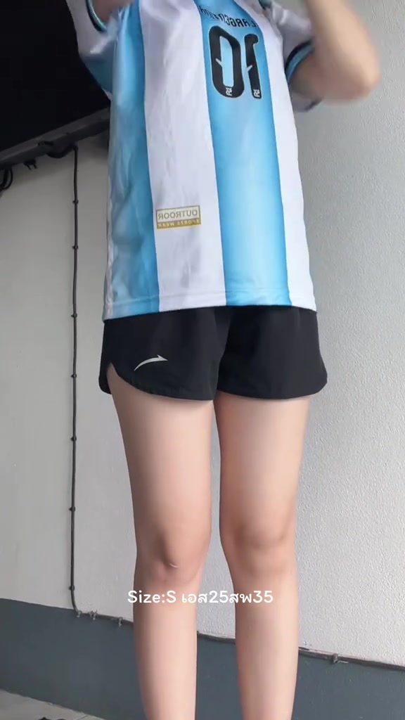 ด้านข้างของผู้หญิงตั้งแต่คอลงมาใส่กางเกงวิ่งขาสั้นทรงหลวมสีดำ เห็นความยาวขากางเกงและขอบเอว