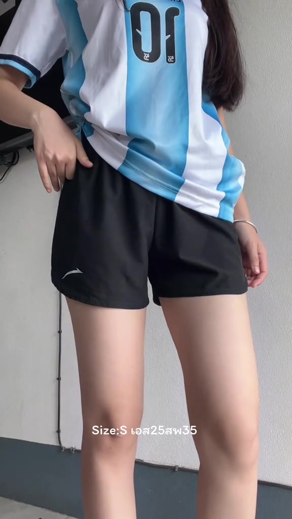 ด้านข้างของผู้หญิงตั้งแต่คอลงมาใส่กางเกงวิ่งขาสั้นสีดำ มือสอดอยู่ที่กระเป๋าข้างกางเกง