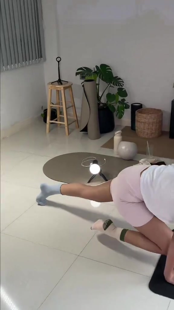 คนท่าแพลงก์บนเสื่อในบ้านสวมถุงเท้ากันลื่น เห็นตั้งแต่ช่วงคอลงมา ไม่เห็นใบหน้า