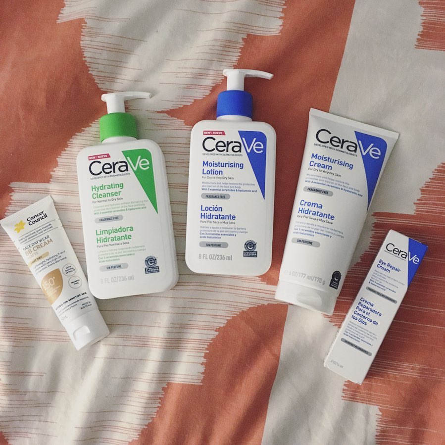 ขวดและหลอดสกินแคร์เซราวีหลายชิ้นเรียงบนผ้าลาย รวมถึงกล่องเซราวี อาย รีแพร์ ครีมด้านขวา
