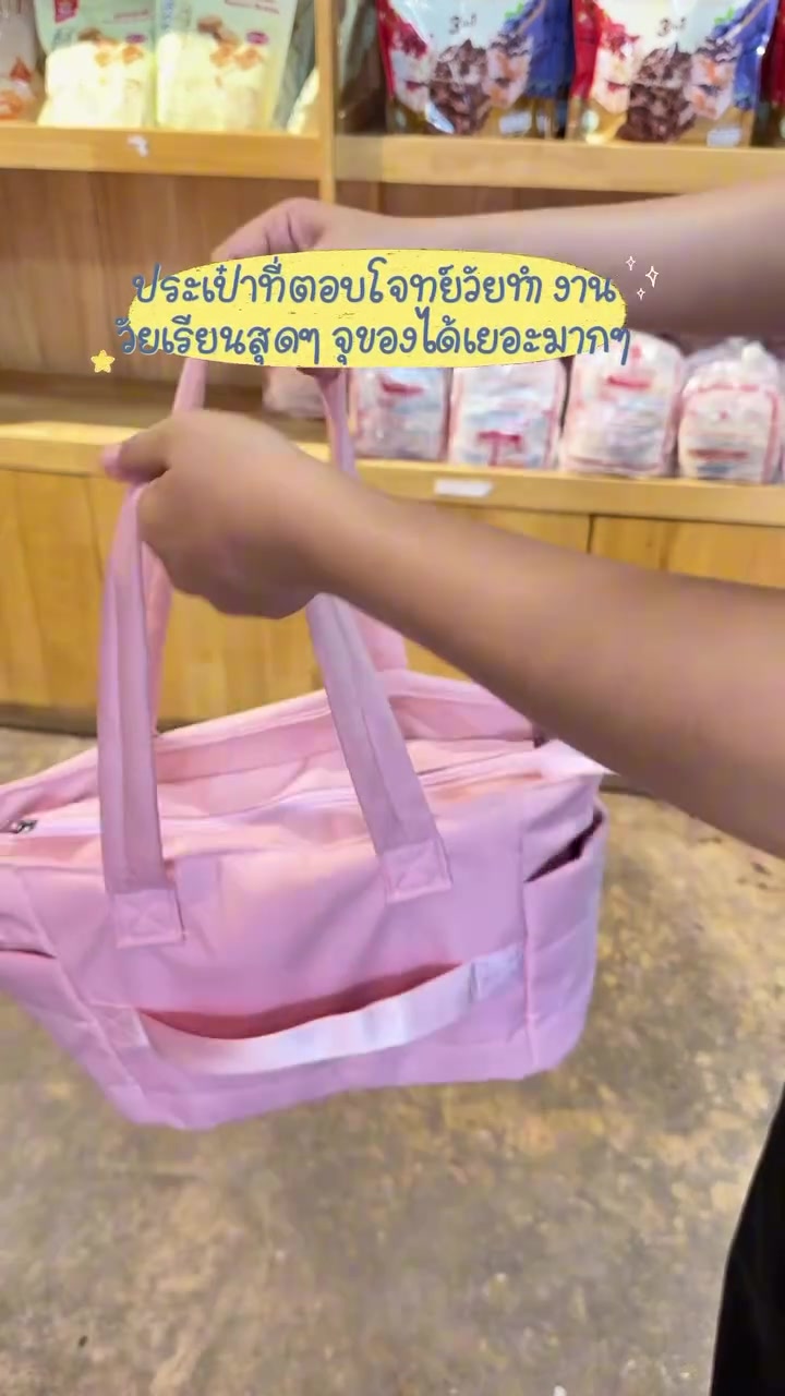 มือหิ้วกระเป๋าโท้ทผ้าไนลอนสีชมพูใบใหญ่โชว์หูหิ้วคู่ภายในร้าน