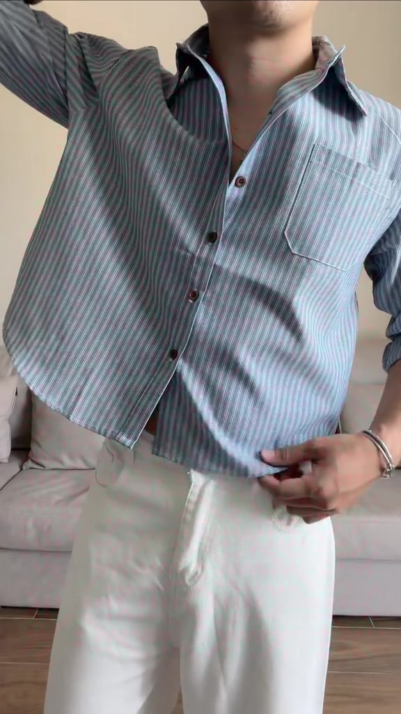 ลุคตัวอย่างเห็นตั้งแต่ช่วงคอลงมา เสื้อเชิ้ตลายทางพื้นฟ้าทรงครอปใส่กับกางเกงขายาวสีขาว