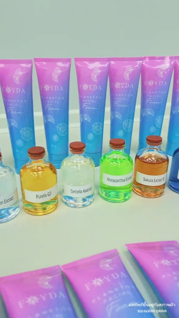 หลอดโฟมล้างหน้าเฟย์ด้าสีชมพูไล่ฟ้าเรียงเป็นแถว พร้อมขวดสารสกัดหลายสีวางเรียงด้านหน้า