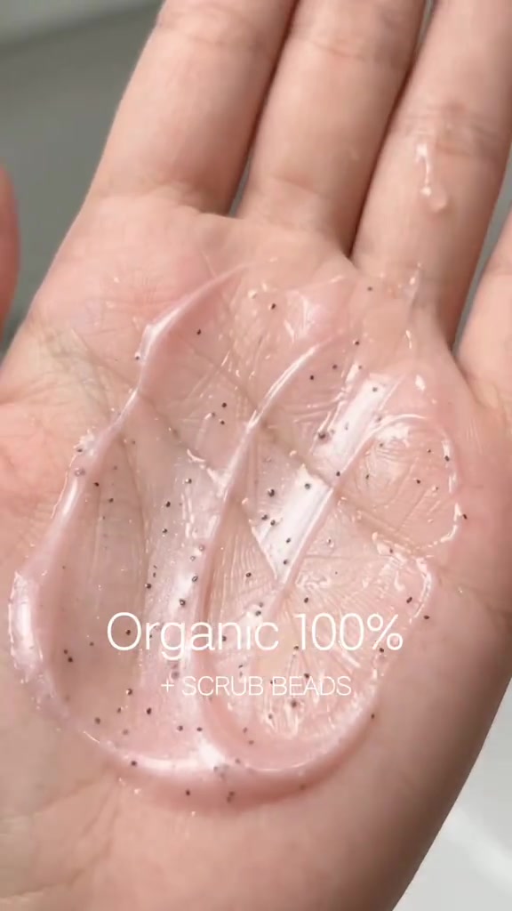 เนื้อคลีนเซอร์สีชมพูโปร่งแสงมีเม็ดสครับเม็ดเล็กเกลี่ยอยู่บนฝ่ามือ