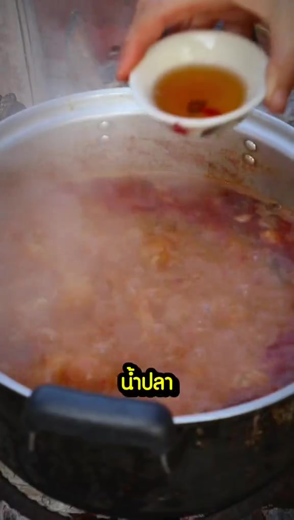 น้ำแกงน้ำเงี้ยวสีแดงกำลังเคี่ยวในหม้อ ก่อนเติมส่วนผสมอื่น