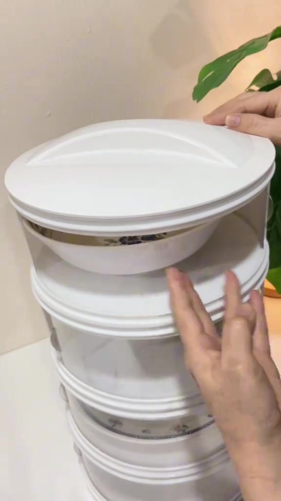 มือแตะขอบฝาครอบของชั้นเก็บอาหารสีอ่อน มีภาชนะวางอยู่ในช่องด้านใน
