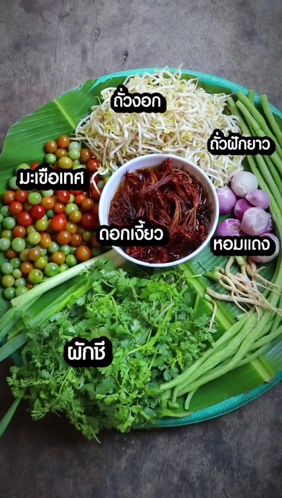 ถาดวัตถุดิบสำหรับน้ำเงี้ยว มีเส้น ถั่วงอก และผักสดวางล้อมชามเครื่องแกง