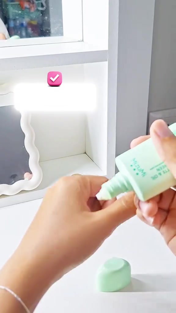 มือบีบเนื้อกันแดดจากหลอดลงบนฝ่ามือ