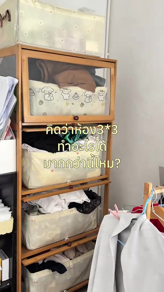 ชั้นเก็บเสื้อผ้าและกล่องหลายใบในห้องนอนขนาดเล็ก